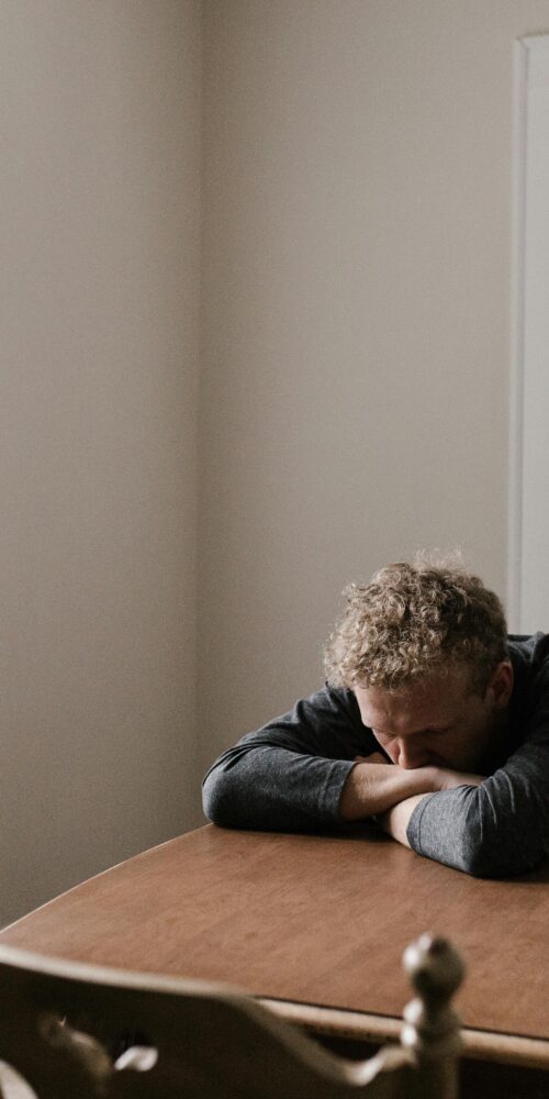 Depressed man sitting at table.